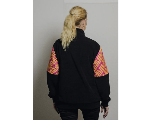 Vue arrière d'une femme portant un pull en polaire noir avec des manches à motifs