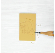 Gomme avec motif de raton laveur en cours de traitement avec un outil de découpe.