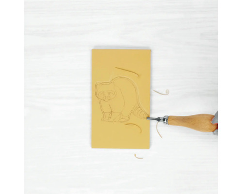 Gomme avec motif de raton laveur en cours de traitement avec un outil de découpe.