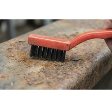 Brosse métallique éliminant la rouille du métal.