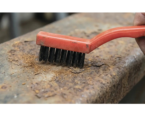 Brosse métallique éliminant la rouille du métal.