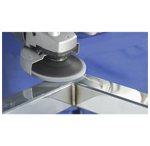 Meuleuse d'angle avec disque abrasif traitant une soudure sur un cadre métallique.