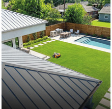 Ansicht eines Gartens mit Rasenmäherroboter, Grillplatz, Esstisch und Pool.