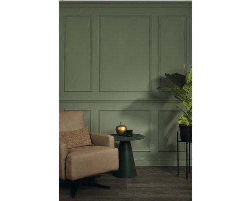 Salon avec fauteuil, table d'appoint et plante d'intérieur devant un mur avec des panneaux