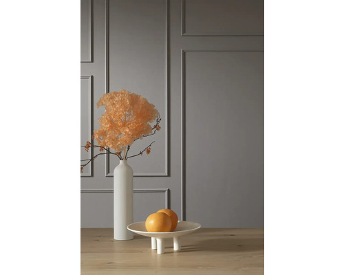 Scène décorative avec fleurs séchées dans un vase et une coupe à fruits sur une table