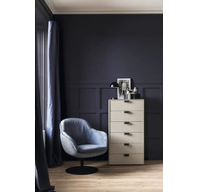 Vue d'une pièce avec un fauteuil, une commode et de la décoration