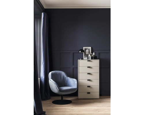 Vue d'une pièce avec un fauteuil, une commode et de la décoration