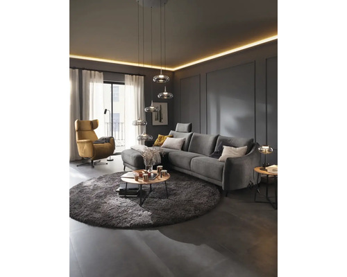 Salon avec canapé, fauteuil, tapis et suspensions