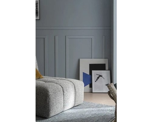 Salon avec pouf rembourré, tapis et tableaux au mur