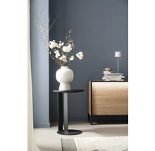 Arrangement décoratif avec des fleurs dans un vase sur une table d'appoint à côté d'une commode