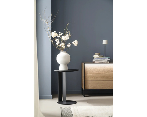 Arrangement décoratif avec des fleurs dans un vase sur une table d'appoint à côté d'une commode