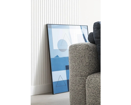 Image décorative avec des formes géométriques dans un cadre à côté du canapé