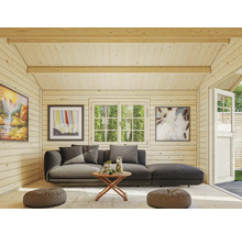 Vue intérieure d'une maison de jardin avec canapé, table, fenêtres et décorations.