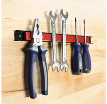 Outils tels que pince, clés et tournevis sur une barre à outils magnétique.