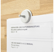 Crochet magnétique tenant un mode d'emploi sur une surface en bois