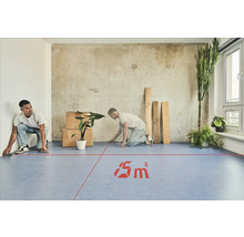 Zwei Männer messen einen Raum mit einem Laser aus, der eine Fläche von 5 Quadratmetern anzeigt.