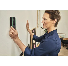 Femme utilisant un scanner mural pour localiser des objets dans un mur