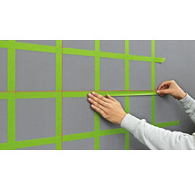 Application de ruban de masquage sur un mur pour préparer des travaux de peinture