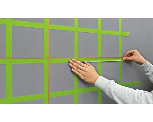 Application de ruban de masquage sur un mur pour préparer des travaux de peinture