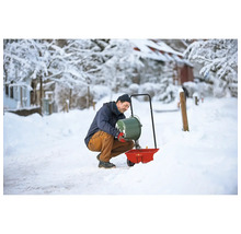 Un homme remplit un épandeur en hiver avec du sel de déneigement