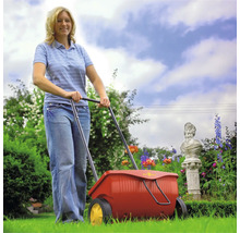 Femme utilisant un épandeur dans le jardin