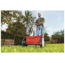 Ein Mann benutzt einen Düngerstreuer der Marke Wolf Garten im Garten.