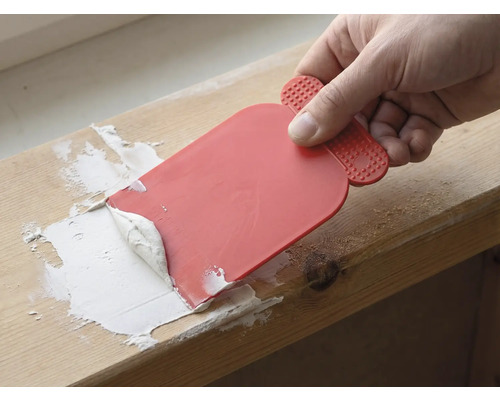 Handwerker verwendet einen Spachtel, um Fugenmasse aufzutragen.