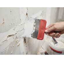 Handwerker verspachtelt eine Wand mit einem Spachtel