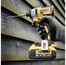 Visseuse à percussion sans fil avec vis dans un mur en bois