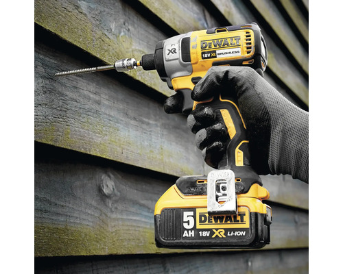 Visseuse à percussion sans fil avec vis dans un mur en bois