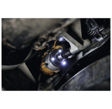 Vue sous une voiture avec une clé à chocs éclairée de la marque DeWalt