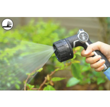 Une personne tient un pistolet d'arrosage qui projette de l'eau