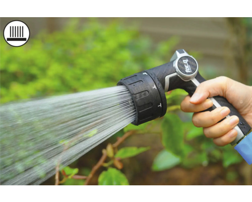 Main tenant un pistolet d'arrosage pendant l'arrosage