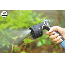 Main tenant un pistolet d'arrosage avec jet