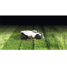 Robot tondeuse à gazon en fonctionnement sur une pelouse.