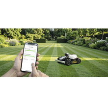 Scène avec un robot tondeuse à gazon sur une pelouse et une personne utilisant un smartphone pour contrôler l'appareil