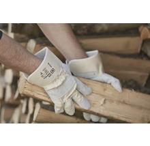Un homme manipule du bois avec des gants de travail.