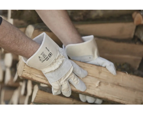 Un homme manipule du bois avec des gants de travail.