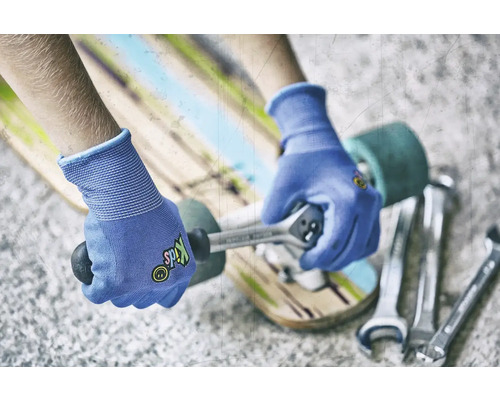 Personne réparant un skateboard avec une clé et des gants