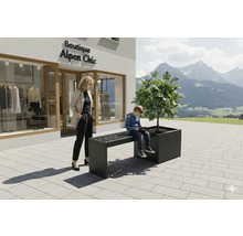 Bank mit Pflanzkasten vor einem Geschäft mit Alpenchic-Motiven, eine Frau und ein Kind