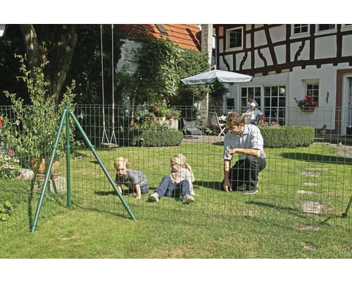Famille avec clôture de sécurité pour enfants dans le jardin