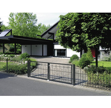 Einfahrtstor aus Metall vor einem modernen Wohnhaus mit Carport und Garten