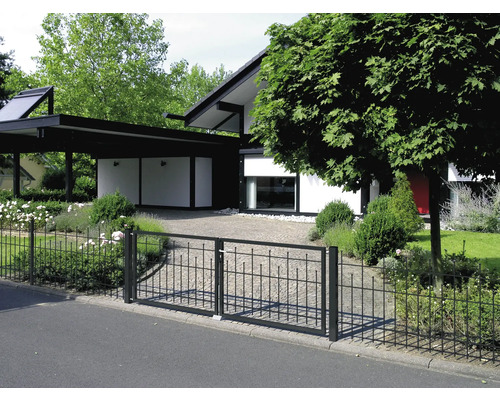 Einfahrtstor aus Metall vor einem modernen Wohnhaus mit Carport und Garten