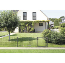 Gartenansicht mit Metallzaun und Gartentür vor einem Wohnhaus