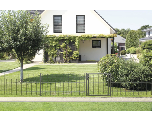 Gartenansicht mit Metallzaun und Gartentür vor einem Wohnhaus