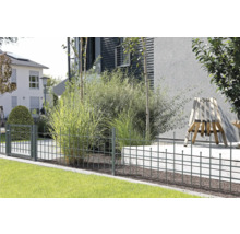 Eingezäunter Garten mit Metallzaun und Tor vor Wohnhäusern