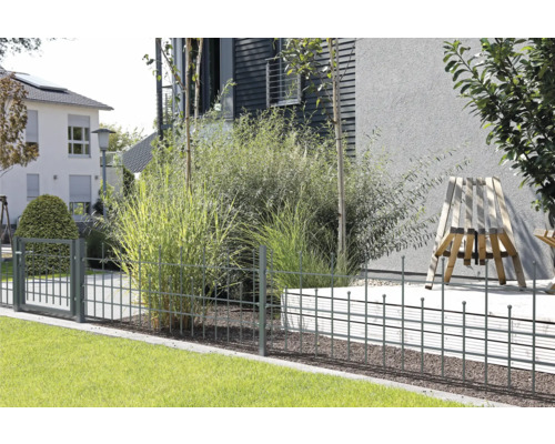 Eingezäunter Garten mit Metallzaun und Tor vor Wohnhäusern