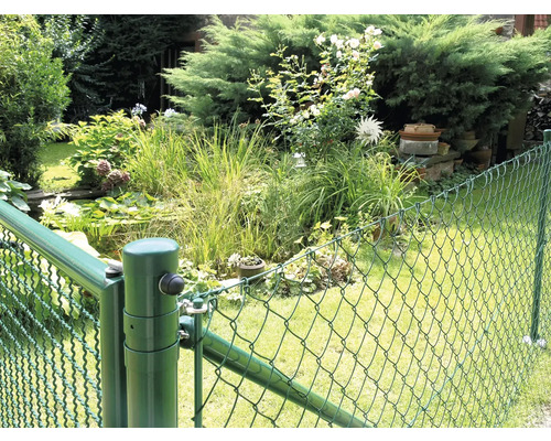 Clôture grillagée verte autour d'un jardin avec bassin et plantes