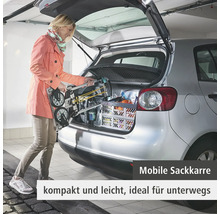 Frau lädt eine mobile Sackkarre in das Heck eines Autos