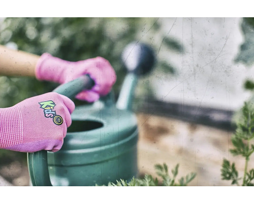 Des mains gantées d'enfants tiennent un arrosoir